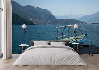 Traditional standing rowboat “Lucia” with lake como, Italy in the background Wall mural