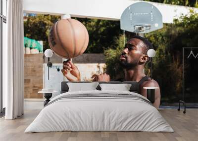 African american player spinning a ball on his finger on outdoor court Wall mural