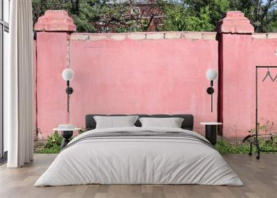 Fence of bricks. Wall with brick and cracked stucco of pink color Wall mural