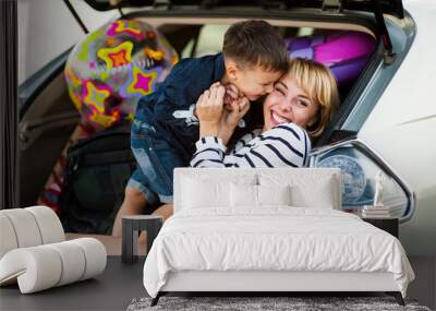 Beautiful woman with a child of four years in the car are going to have a trip Wall mural