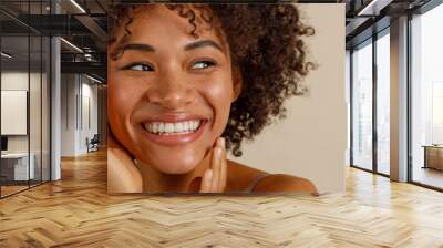 Attractive multiracial woman posing at camera over beige background Wall mural