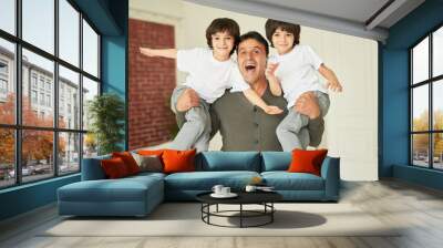 Boys. Portrait of happy latin family, cheerful father holding little twins and smiling at camera while posing, having fun together at home Wall mural