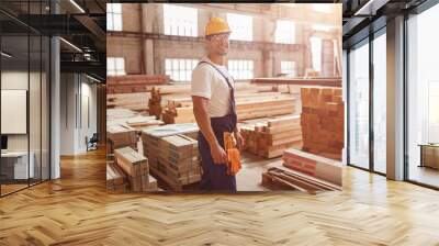 Cheerful male worker standing by construction materials Wall mural