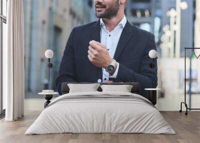 Confident businessman. Cropped shot of businessman in stylish suit straightens the sleeve Wall mural