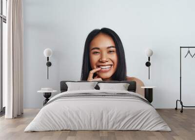 Having fun. Close up portrait of young beautiful asian woman looking at camera and smiling while standing on a grey background. Positive emotions Wall mural