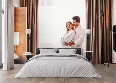 Honeymoon in hotel. Young couple travel together hotel room leisure Wall mural