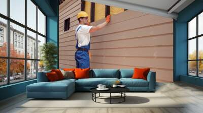 Male worker building house at construction site Wall mural