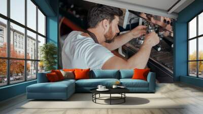 Man worker in uniform checking coffee machine in own workshop Wall mural