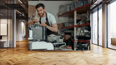 Man worker repair a coffee machine in own workshop and looking camera Wall mural