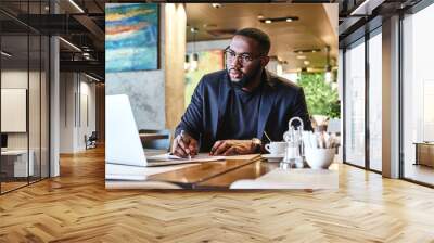 Nothing worth having comes easy. African american businessman is working, using his laptop while resting in the cafe Wall mural