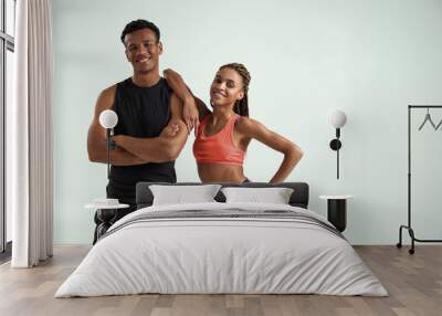 Sporty and healthy. Young african fitness couple in sportswear looking at camera and smiling while standing against grey background Wall mural