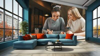 Succeeding together. Businesswomen have a meeting in a modern cafe Wall mural