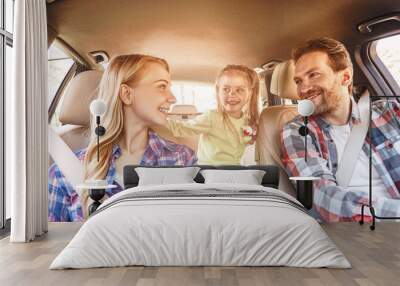 To travel is to live. Smiling family sitting in the car and driving. Family road trip Wall mural