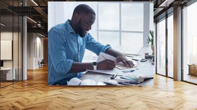 Young african man working in the office business Wall mural