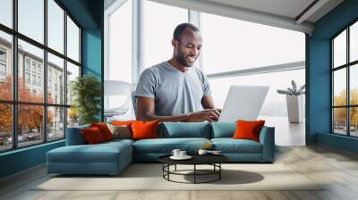 young businessman working on his laptop in spacious bright office. Wall mural