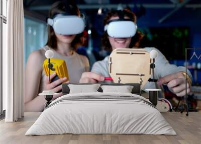 Two young engineers fixing a mechanical robot in the workshop, using VR virtual reality headsets Wall mural