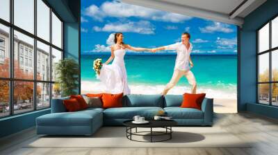 happy bride and groom having fun on a tropical beach Wall mural