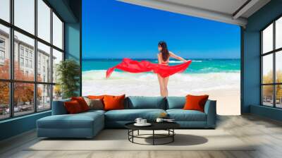 Young beautiful Asian girl with red cloth on the beach of a trop Wall mural