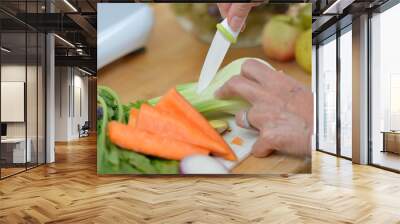 Woman putting vegetables and fruits in extractor to make delicious colored juice Wall mural