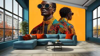 Bold Reflection: A fashion-forward model with bold sunglasses and a vibrant patterned jacket, poses with his reflection against a vivid orange backdrop. Wall mural