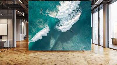 Surfers are seen from above in blue pristine ocean water Wall mural