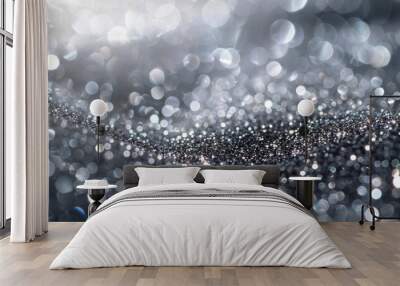 A blurred image featuring a black and white background with sparkling silver particles creating a bokeh effect. Wall mural