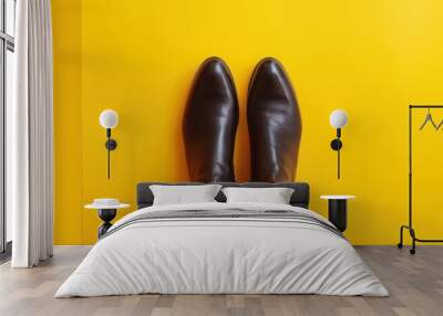 A close-up photograph showcasing a pair of brown leather shoes resting on top of a vibrant yellow floor. Wall mural