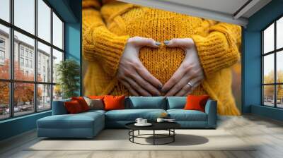 Expectant mother cradling her baby bump in a cozy sweater during autumn Wall mural