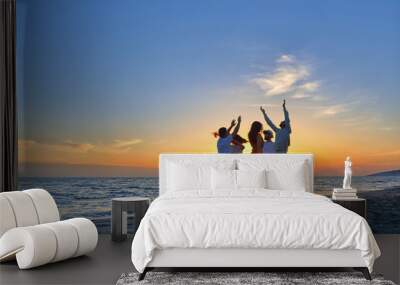 group of happy young people dancing at the beach on beautiful summer sunset Wall mural