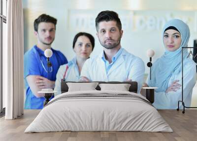 healthcare and medicine concept - attractive male doctor in front of medical group in hospital showing thumbs up Wall mural