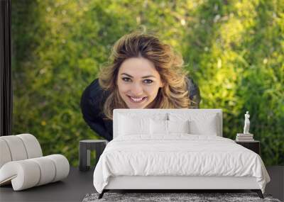 high angle view of beautiful happy girl smiling at camera while standing on green grass Wall mural