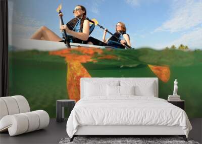 Two young women smiling in kayak Wall mural