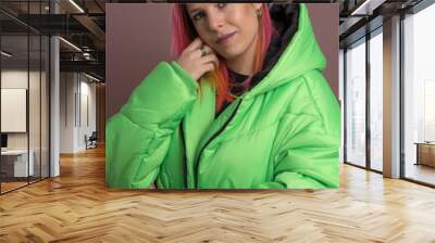 Young female with pink hair wearing a green puffer jacket Wall mural