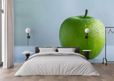 A close-up of a green apple covered in water droplets on a light blue surface. Wall mural