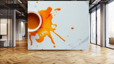 A cup of coffee with a large orange stain on a white marble background. Wall mural