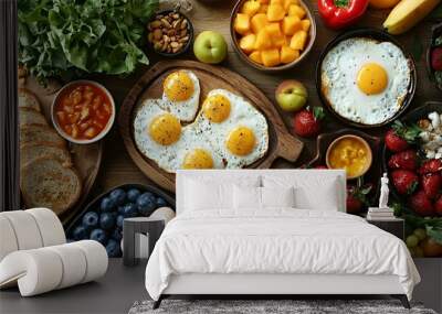 A delicious and colorful breakfast spread with fried eggs, toast, fruit, and berries. Wall mural