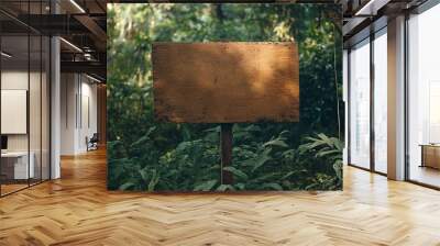 A weathered wooden sign stands in a lush green forest, perfect for adding your own message. Wall mural