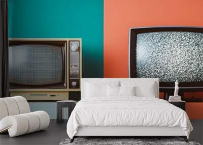 Two vintage televisions side by side on a white shelf against a teal and orange background. One TV has static on the screen, while the other one is off. Wall mural