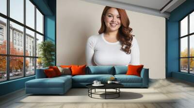 Beautiful voluptuous chubby woman in bright colours posing smiling Wall mural