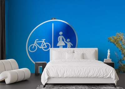 blue sign with a bicycle and a child on it Wall mural