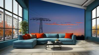 Electricity pylon and power lines at sunset silhouetted against a colorful orange and blue twilight sky with copy space Wall mural