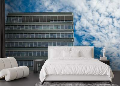 tall building with many windows and a cloudy sky in the background Wall mural