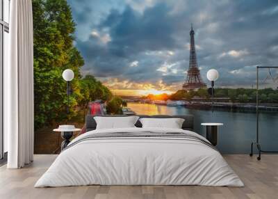 Scenic view over the Eiffel Tower from a bridge at sunrise. Paris, France. Beautiful travel background with rising sun and dramatic clouds. Wall mural