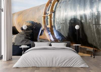 The welder is welding to large spiral welded pipes with gas metal arc welding process. Wall mural