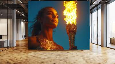 powerful image of female athlete holding olympic torch aloft against clear blue sky embodying strength and determination Wall mural