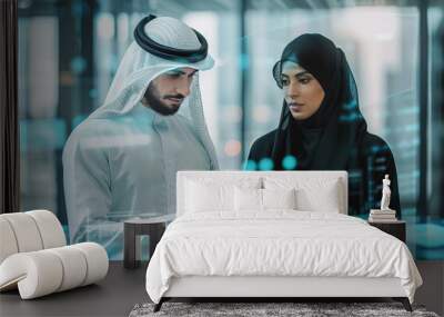 Businessman in Kandora clothes and businesswoman in traditional Abaya dress checking report on tablet during a meeting in futuristic conference room with virtual holograms. Wall mural