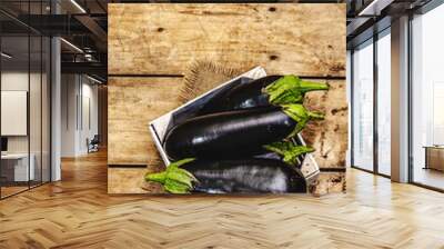 Whole unpeeled raw eggplants in a wooden crate Wall mural