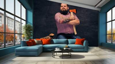 a bearded lumberjack dressed in a pink fleece shirt holds the axe. Wall mural