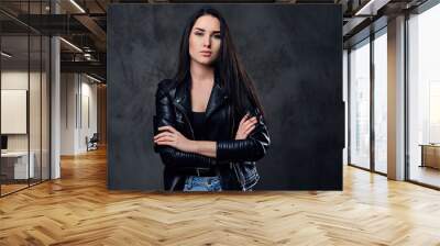 A fashionable brunette female dressed in a black leather jacket. Wall mural