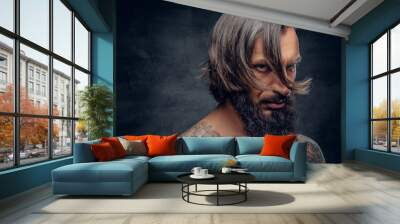 Bearded male with long hair and tattooed chest. Wall mural